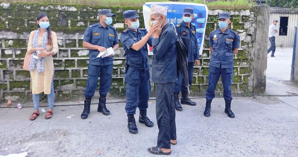 दार्चुलामा मास्क नलगाइ हिड्नेलाई मास्क वितरण गर्दै  प्रहरी